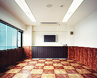 【 Aビル・2F会議室 】重みのある雰囲気にした会議室、床は2色の木風タイル、壁の下半分を模様の強い木にすることで、重厚感ある雰囲気に。